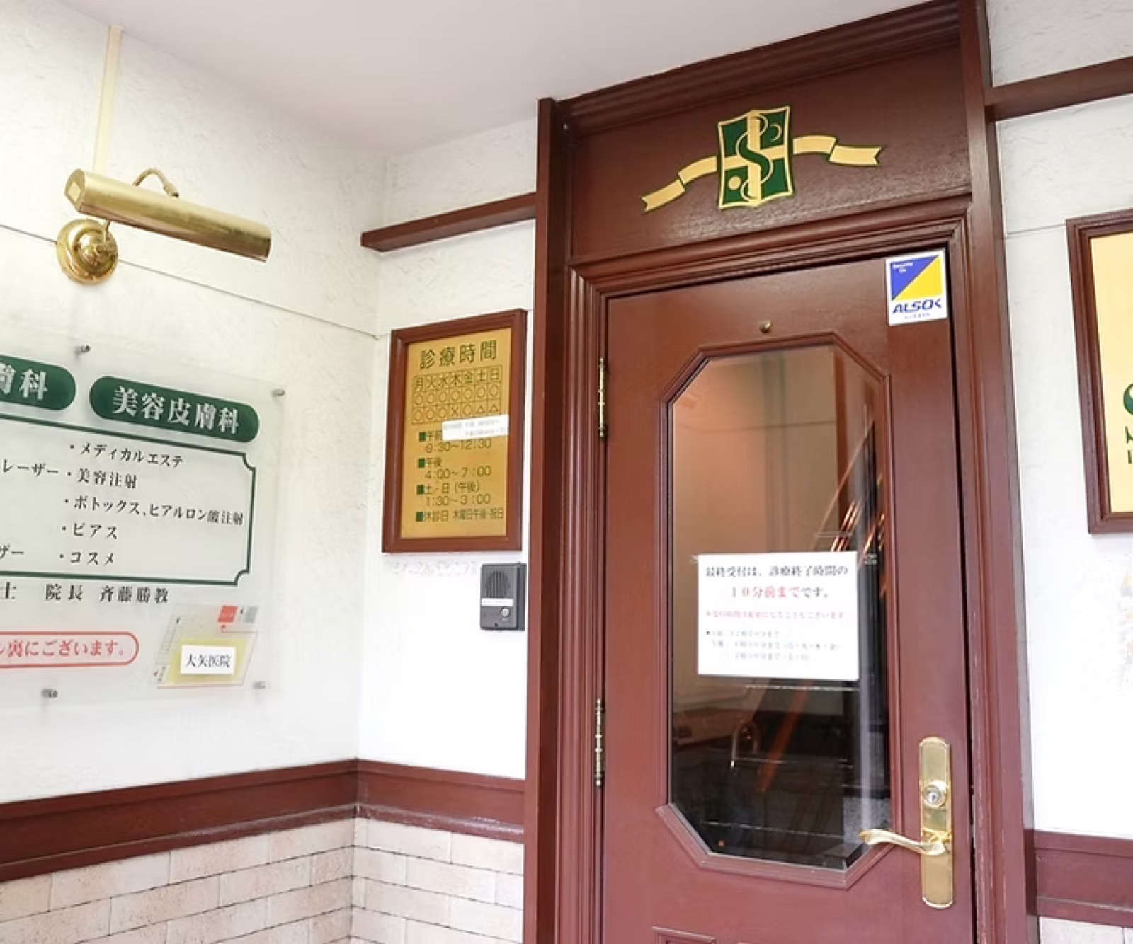 斉藤皮フ科クリニックの入口。紋章の入ったマルーンの扉が目印です